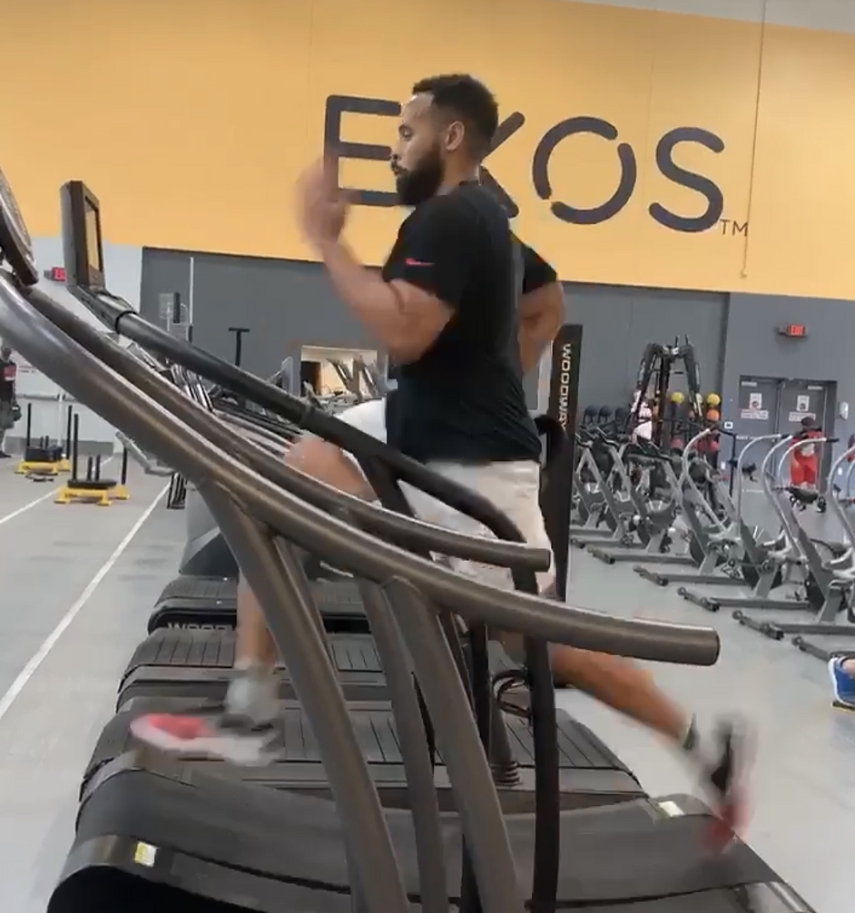 a man running on a treadmill in a gym.