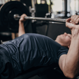Side-by-side comparison of a painful barbell bench press and a rehab-focused bench press with no weight, demonstrating improper vs. proper technique.